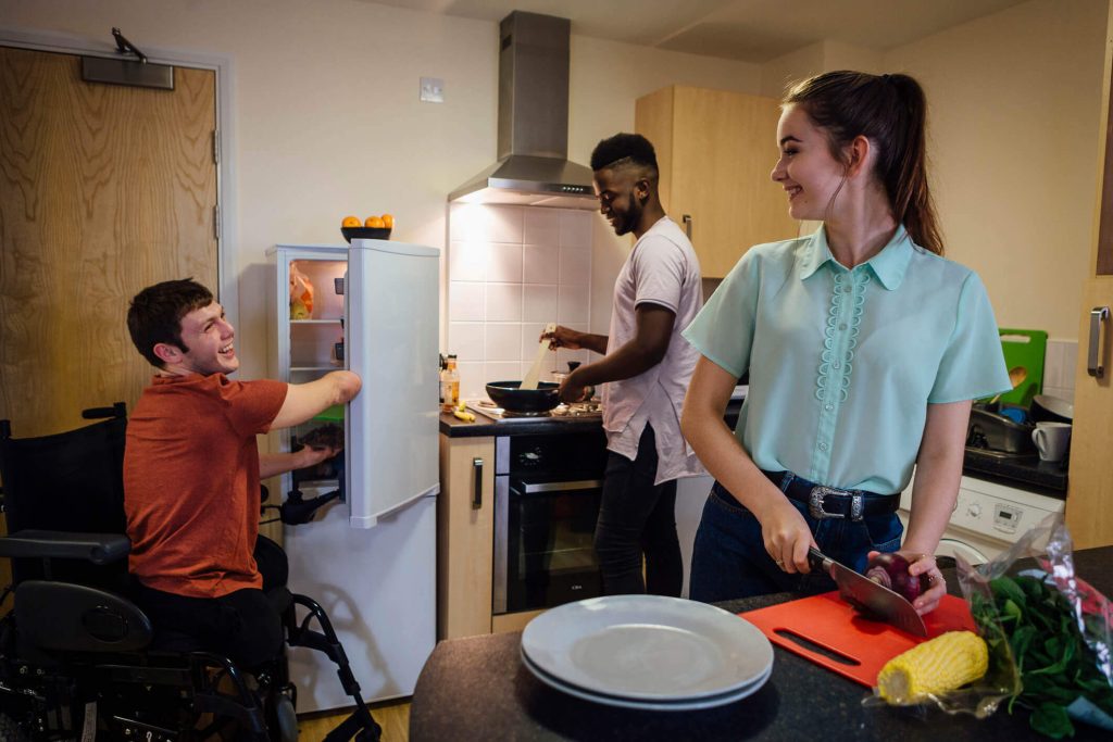 housemates with support needs cooking together in a shared kitchen environment.
