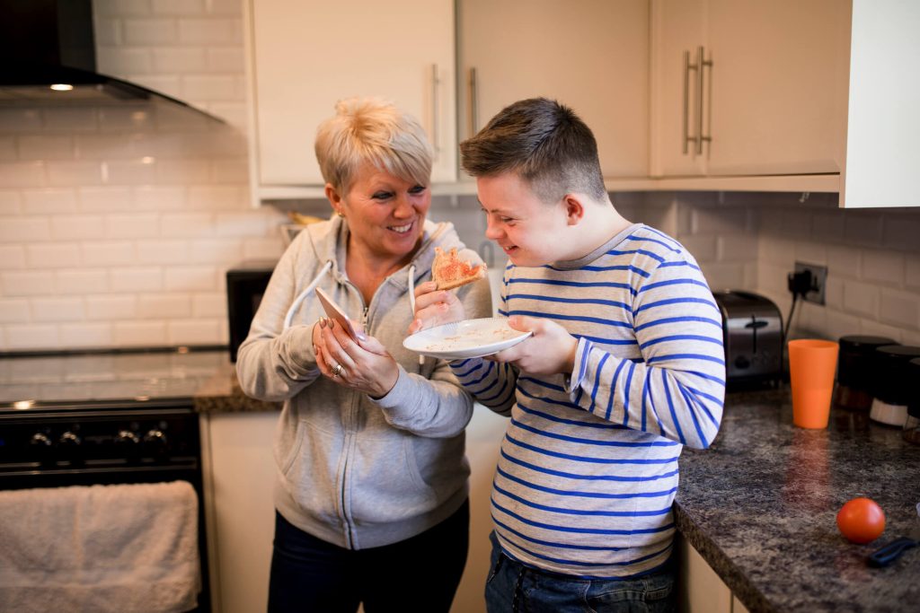 Caregiver helping a person with grooming and dressing in a private room